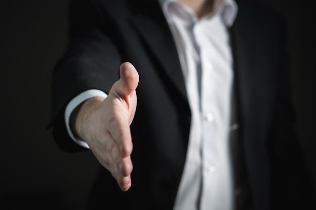 man in suit holding out hand for handshake